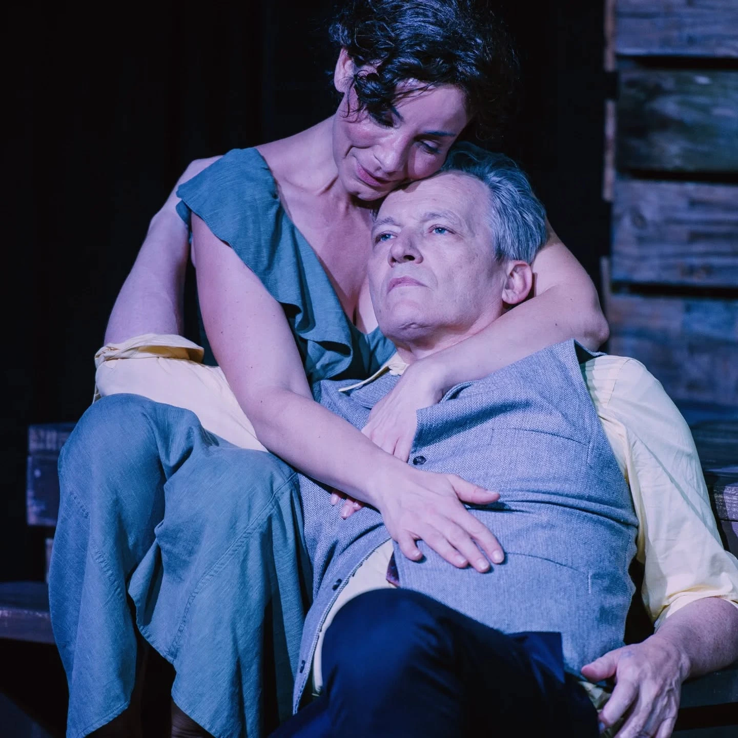 Josie holds Tyrone in her arms under cool lighting in 'A Moon for the Misbegotten' at ABET.