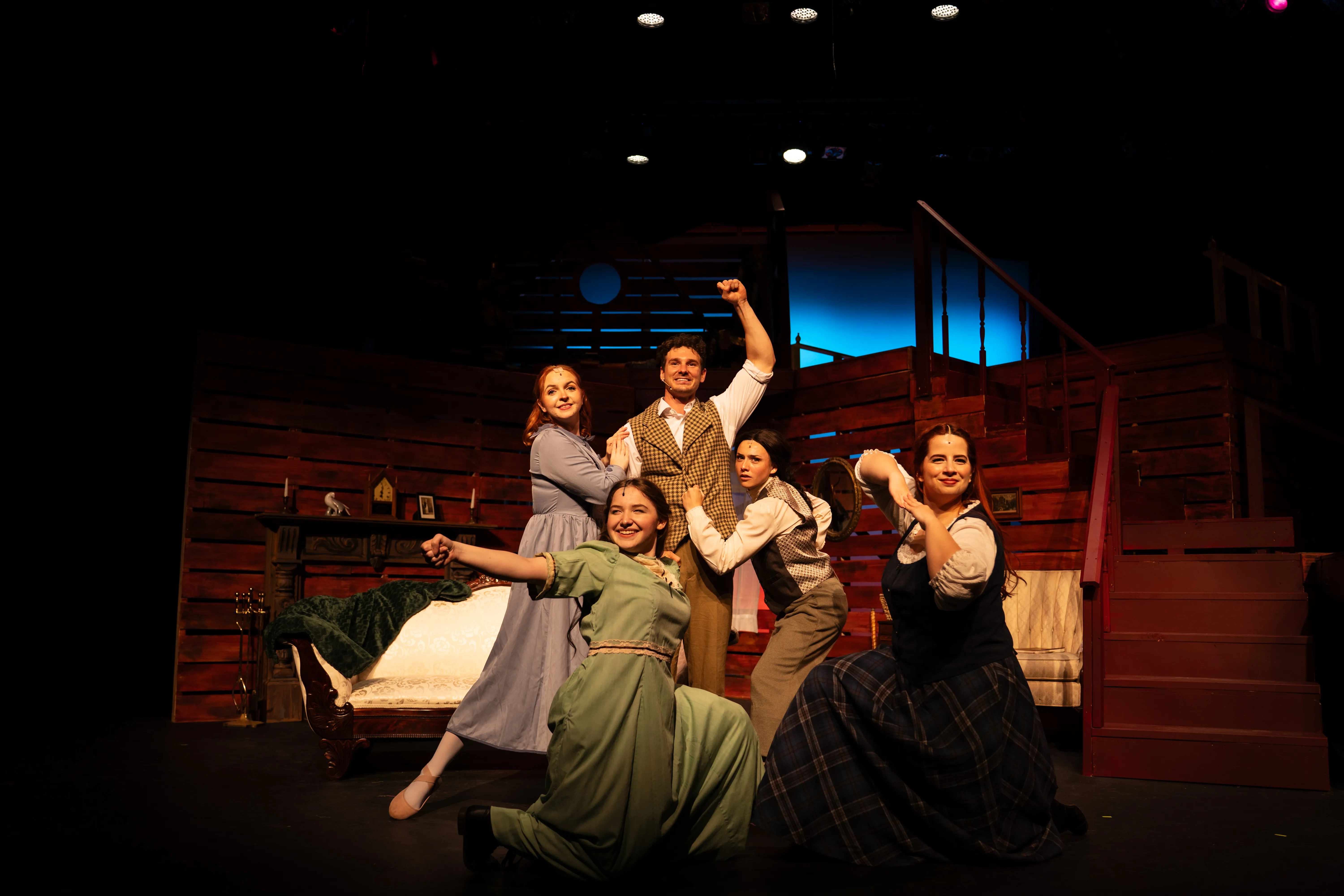 Cast members portraying Jo, Meg, Beth, Amy and Laurie pose together onstage in a lively tableau from the Amelia Community Theatre production of 'Little Women'.